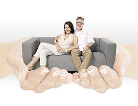 Mann und Frau sitzen auf Sofa auf Händen - Münchener Verein Demenz-Zusatzversicherung