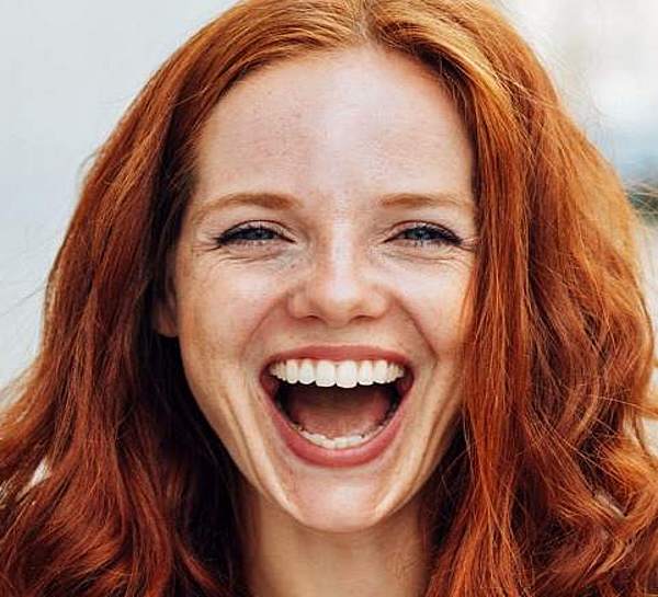 Ratgeber Zahn-Sympathische junge Frau lacht herzlich und zeigt strahlend weiße  Zähne