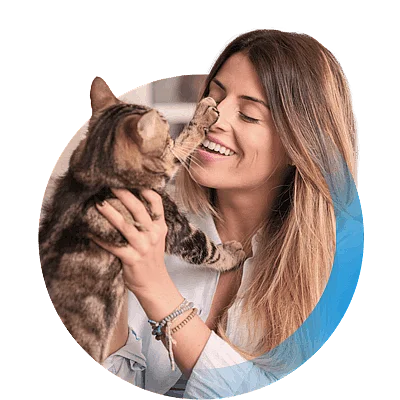 Bild einer Frau, die ihre Katze auf dem Arm h&auml;lt und sie ansieht.