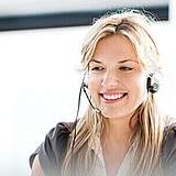 Frau mit Headset lächelt - Münchener Verein Gesundheitsservices