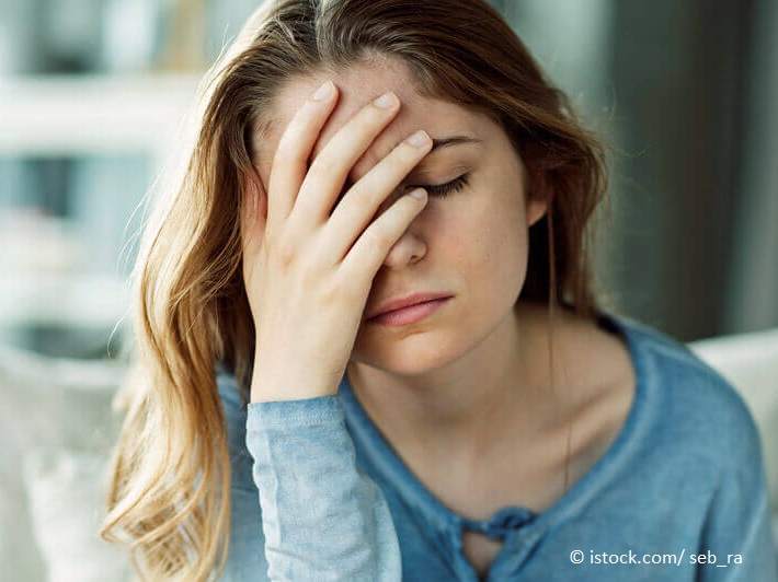 Die besten Hausmittel gegen Kopfschmerzen – junge Frau mit Kopfschmerzen