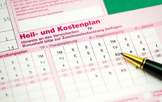 Ausschnitt eines Heil- und Kostenplans, auf dem ein Stift liegt.