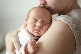 Bild eines Babys im Arm seiner Mutter.