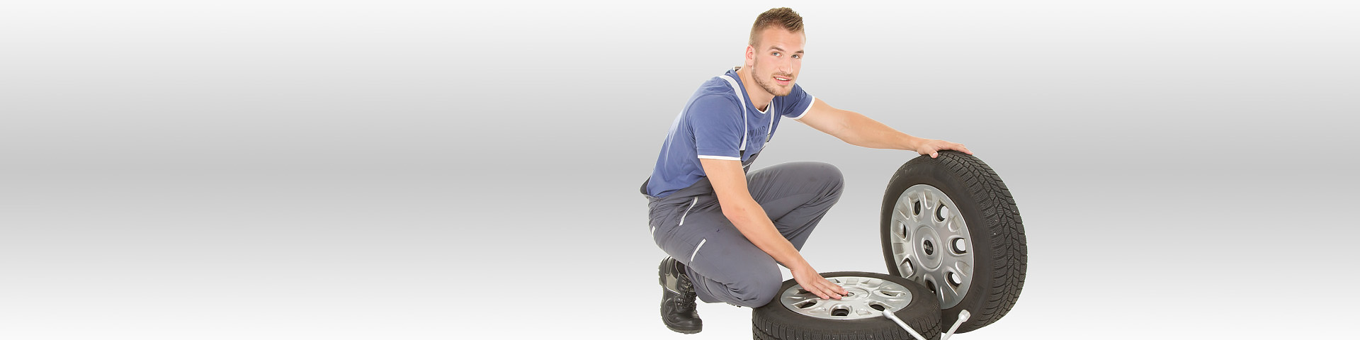 Junger Mann beim Reifenwechsel - Kfz-Versicherung vom Münchener Verein