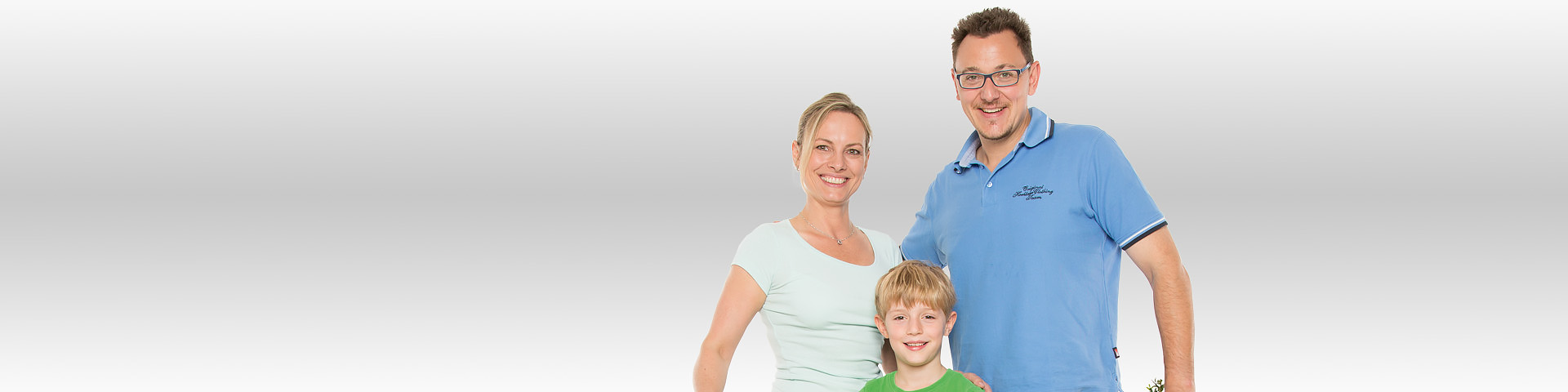 Eine junge Familie steht lächelnd beieinander - Münchener Verein Haus- und Grundbesitzerhaftpflichtversicherung