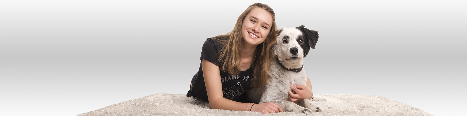 Eine junge Frau kuschelt sich zufrieden und glücklich an ihren Hund - Münchener Verein Tierhalterhaftpflichtversicherung
