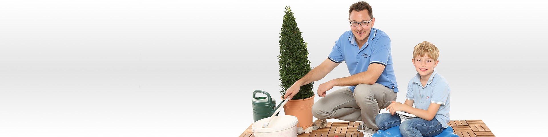 Vater und Sohn arbeiten zusammen auf der Terrasse ihres Hauses - Münchener Verein Wohngebäudeversicherung