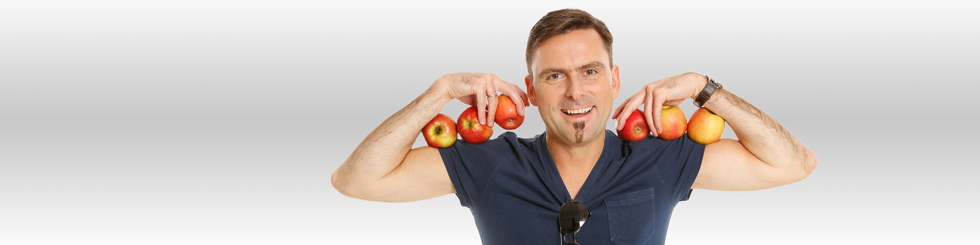 Mann hält Äpfel in den Armen - Münchener Verein Krankenvollversicherung