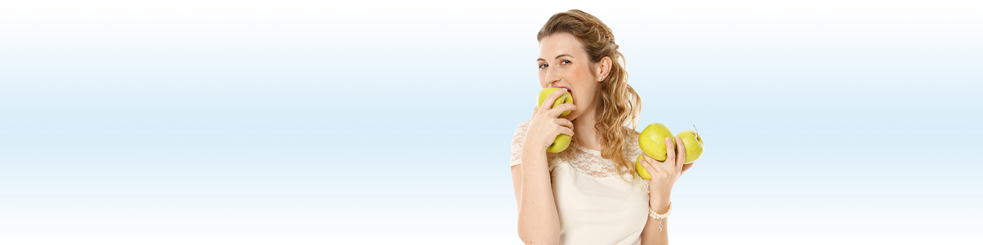 Zahnzusatzversicherung Münchener Verein - Junge Frau beißt in einen Apfel