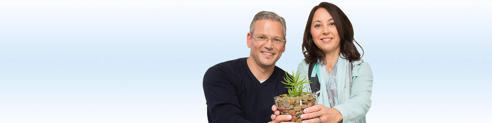 Mann und Frau halten einen Blumentopf voller Münzen - Münchener Verein Geldanlage