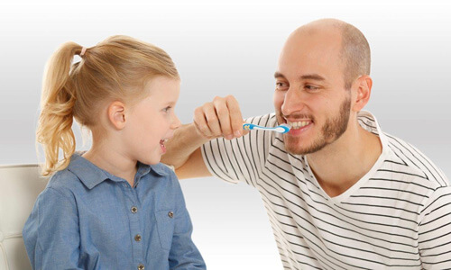 Vater und Tochter beim Zähneputzen - Zahnzusatzversicherung Münchener Verein