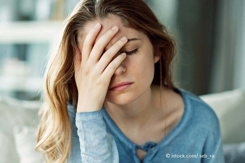 Die besten Hausmittel gegen Kopfschmerzen – junge Frau mit Kopfschmerzen