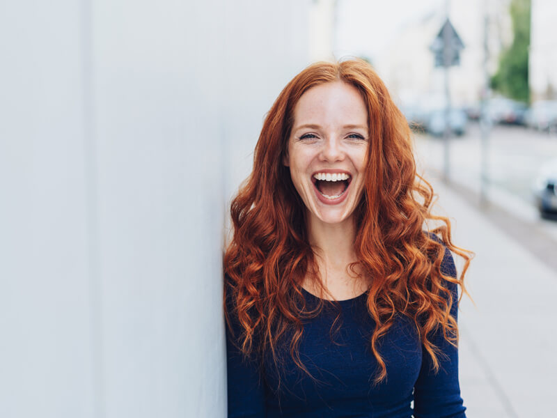 Ratgeber Zahn-Sympathische junge Frau lacht herzlich und zeigt strahlend weiße  Zähne