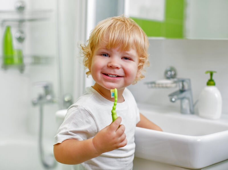 Blondes Kleinkind beim Zähneputzen im Badezimmer 