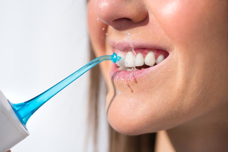 Eine Munddusche kann unter Umständen eine gute Alternative zur Zahnseide sein.
