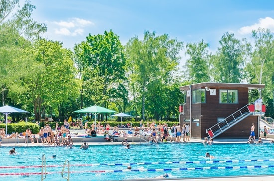 Bild eines Schwimmbeckens in einem gut besuchten Schwimmbad.